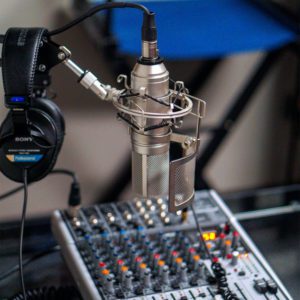 A microphone and headphones on top of a sound board.